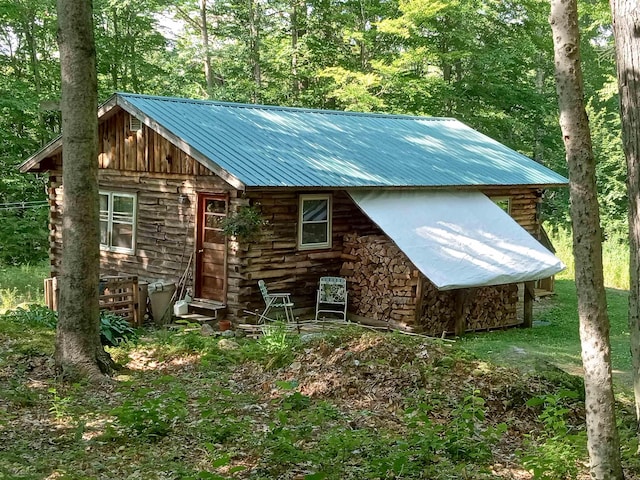 view of front of property with log exterior and metal roof