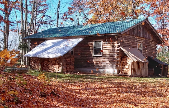 view of property exterior with metal roof and log exterior