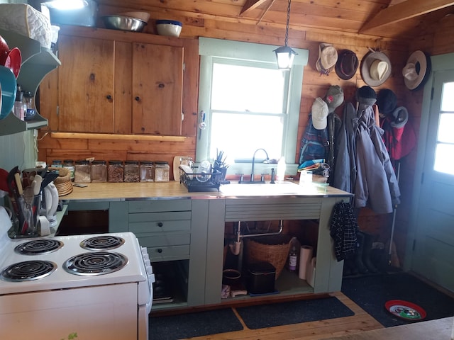 kitchen with wood finished floors, a sink, light countertops, white electric range, and rustic walls