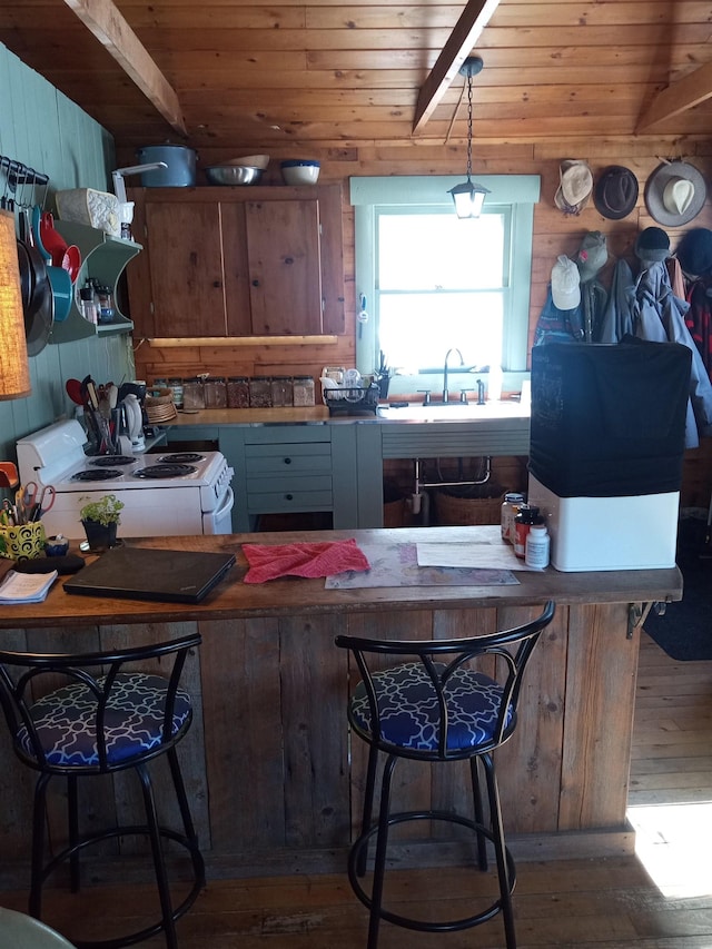 kitchen featuring white range with electric stovetop, wooden walls, wooden ceiling, and wood finished floors