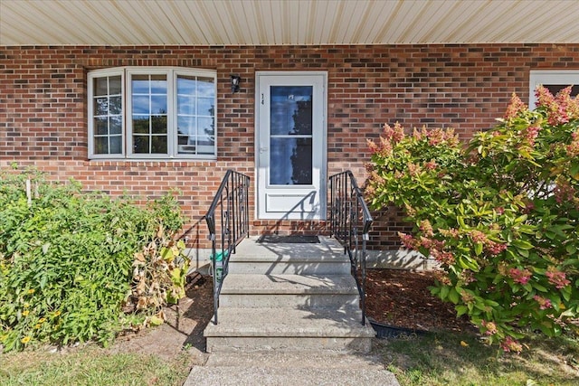 view of exterior entry featuring brick siding