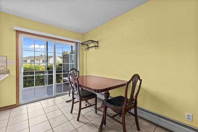 dining space featuring light tile patterned floors, a baseboard heating unit, and baseboards