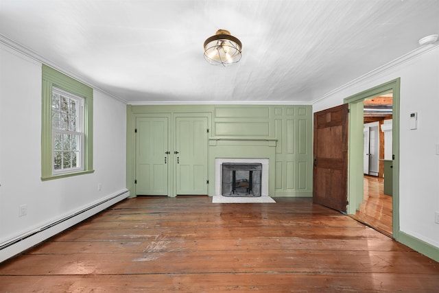 unfurnished living room with a fireplace, baseboard heating, dark wood-style floors, and crown molding