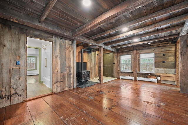 unfurnished living room featuring a baseboard heating unit, beamed ceiling, wood ceiling, a wood stove, and wood-type flooring