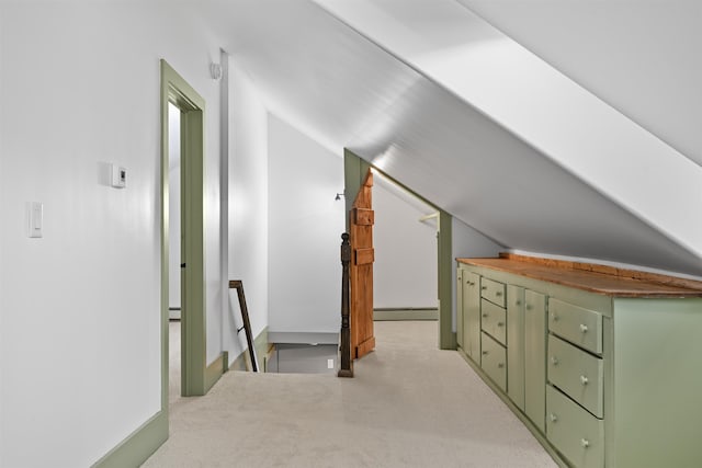 additional living space featuring a baseboard radiator, light carpet, and lofted ceiling