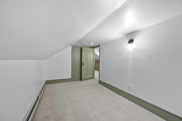 additional living space featuring vaulted ceiling, light carpet, and a baseboard radiator