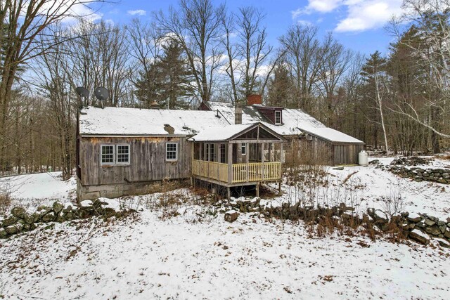 snow covered property with a deck and a chimney