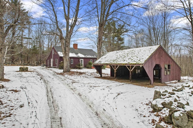 exterior space featuring an outbuilding, a chimney, and an outdoor structure