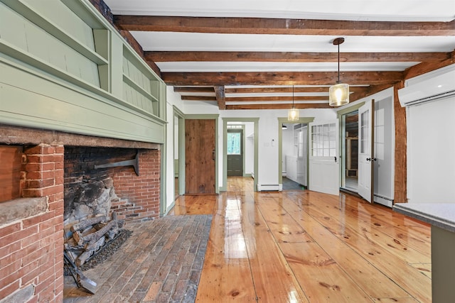 unfurnished living room with beam ceiling, a baseboard radiator, light wood finished floors, and a wall mounted AC