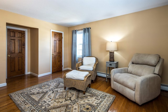 living area with baseboard heating, baseboards, and wood finished floors