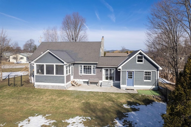 rear view of property with a lawn, entry steps, fence, a sunroom, and a chimney