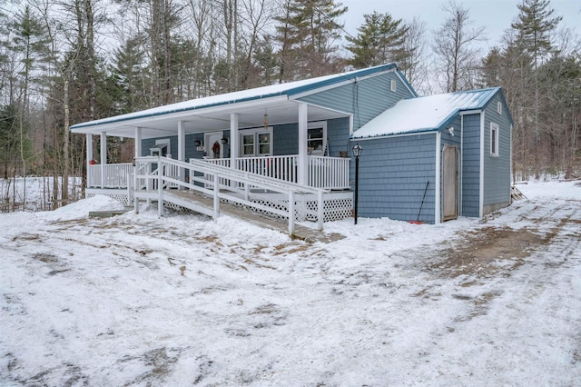 view of front of home with a porch, metal roof, and a garage