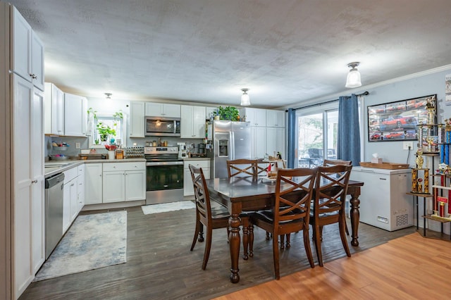 dining space with wood finished floors, crown molding, and a healthy amount of sunlight