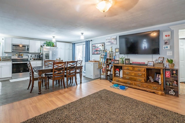 dining area with crown molding and light wood finished floors