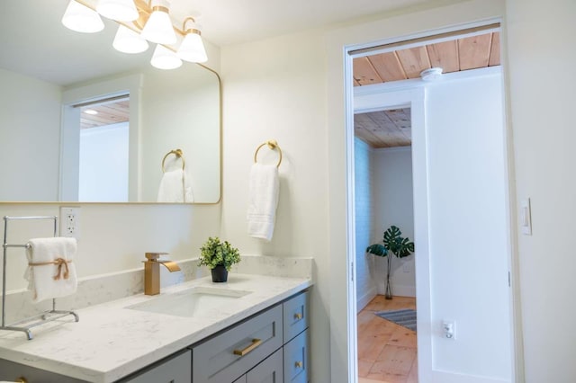 bathroom featuring wooden ceiling, a notable chandelier, wood finished floors, and vanity