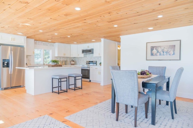 dining area featuring light wood-style flooring, recessed lighting, and wood ceiling