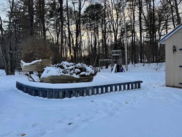 snowy yard featuring a playground