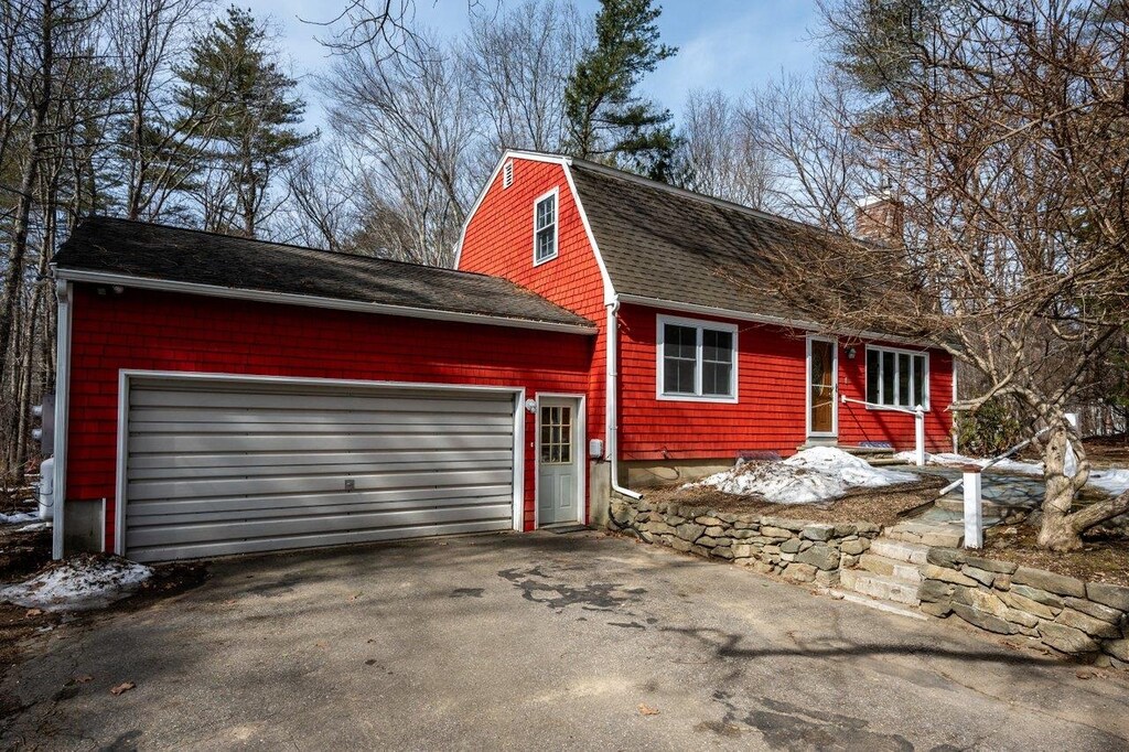 view of front of house featuring aphalt driveway, a gambrel roof, roof with shingles, and an attached garage