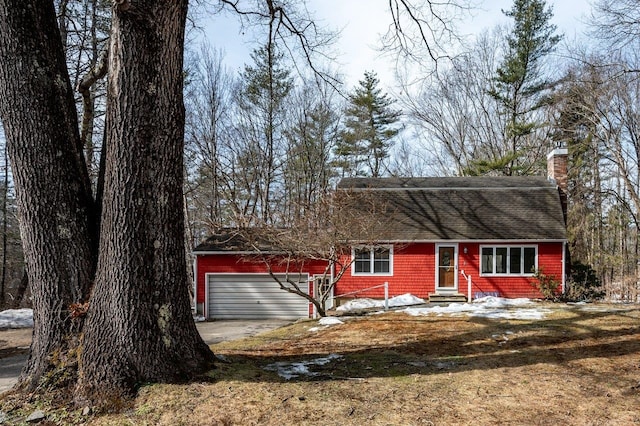 dutch colonial featuring a garage, a chimney, and entry steps