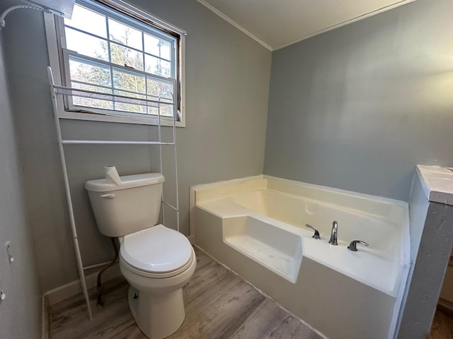 full bathroom featuring a garden tub, crown molding, toilet, and wood finished floors