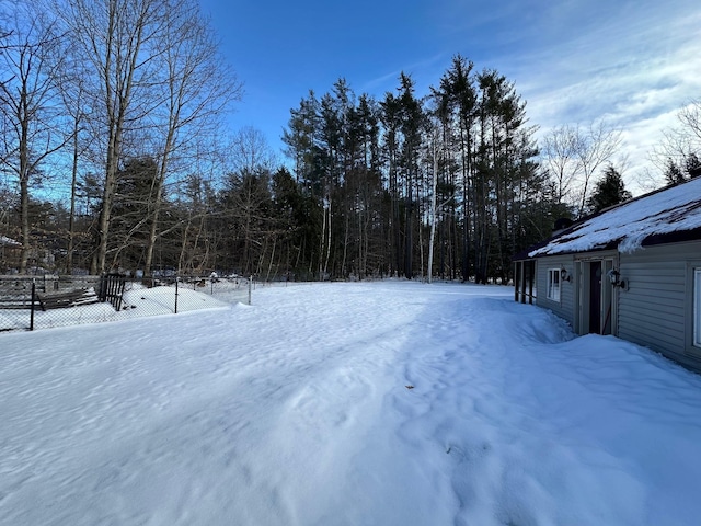 yard covered in snow with fence