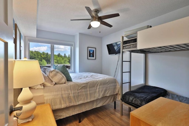 bedroom with a ceiling fan, wood finished floors, and a textured ceiling