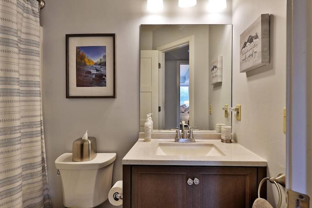 bathroom featuring a shower with shower curtain, toilet, and vanity