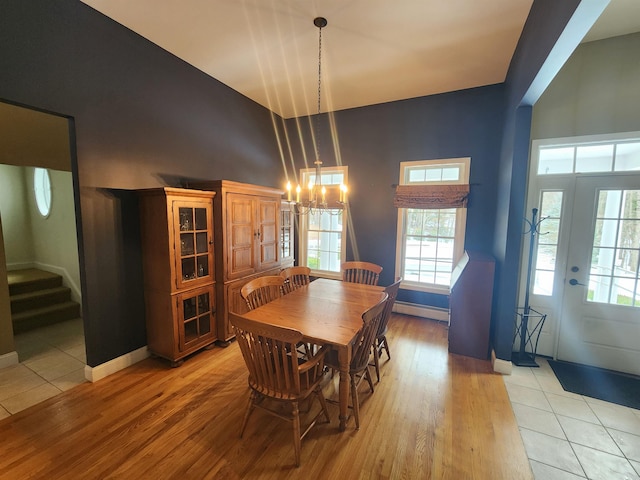 dining room featuring stairway, baseboards, a baseboard radiator, light wood-style flooring, and a notable chandelier