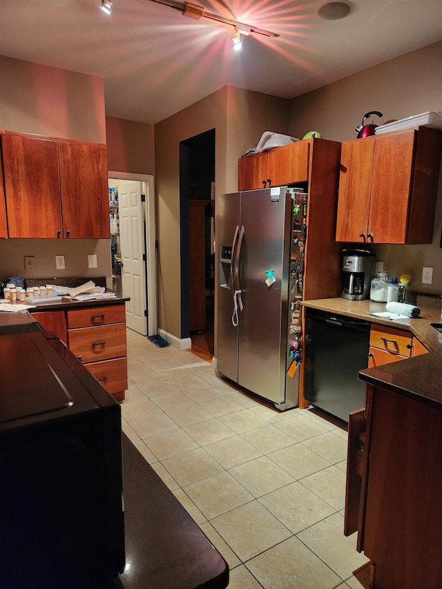 kitchen with brown cabinets, black dishwasher, dark countertops, stainless steel fridge with ice dispenser, and light tile patterned floors