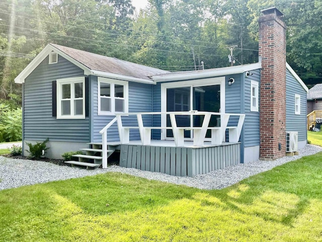 rear view of house featuring roof with shingles, a wooden deck, a yard, a chimney, and ac unit