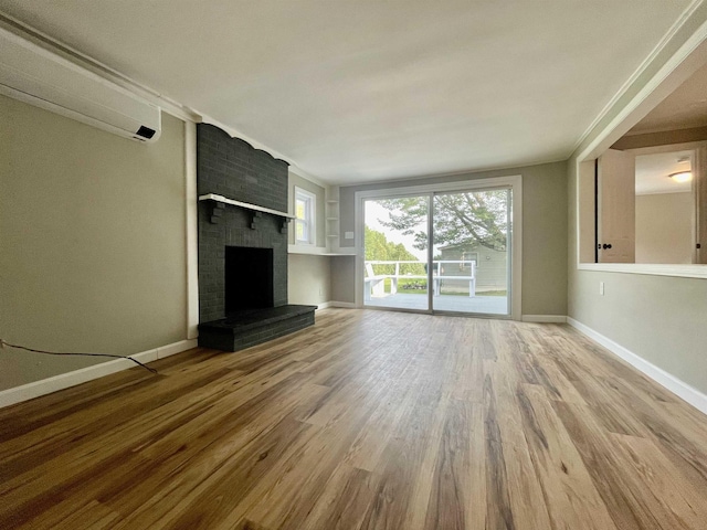 unfurnished living room featuring a fireplace, wood finished floors, and baseboards