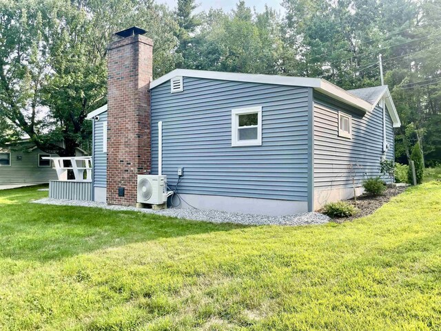 view of property exterior with a chimney, a yard, and ac unit