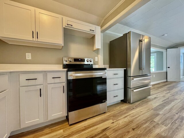 kitchen featuring light wood finished floors, white cabinetry, stainless steel appliances, light countertops, and vaulted ceiling