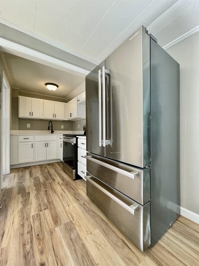 kitchen featuring stainless steel appliances, white cabinets, light countertops, and light wood finished floors