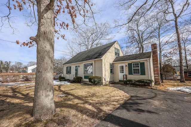 cape cod-style house featuring a chimney