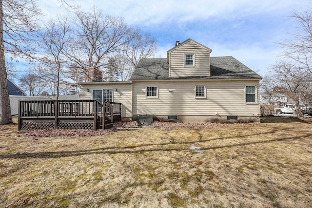 rear view of property with a wooden deck, a chimney, a yard, and roof with shingles