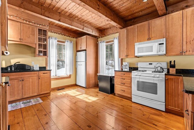 kitchen featuring wood ceiling, beam ceiling, light wood-style floors, white appliances, and a sink