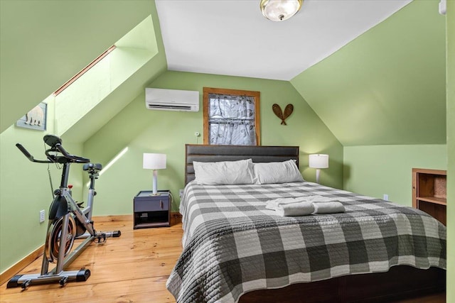 bedroom with lofted ceiling, an AC wall unit, and wood finished floors