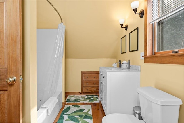full bath with vanity, vaulted ceiling, toilet, and shower / bath combo with shower curtain