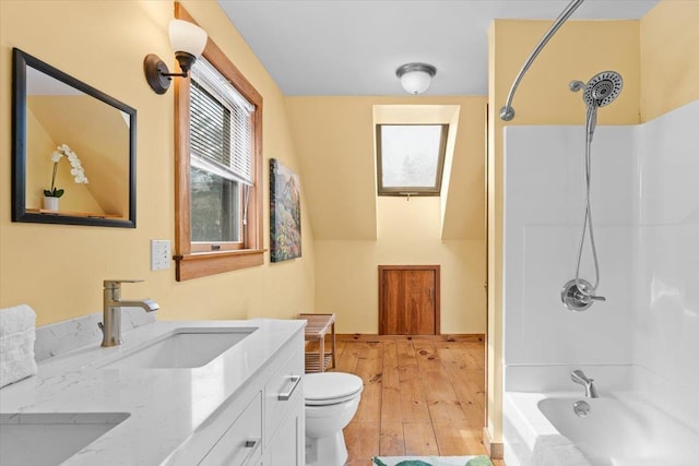 full bath featuring vanity, toilet, wood finished floors, and washtub / shower combination