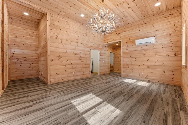 bonus room featuring an AC wall unit, wooden walls, a notable chandelier, and wood finished floors