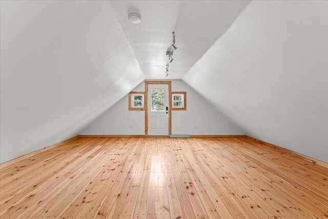bonus room with vaulted ceiling and light wood-style floors