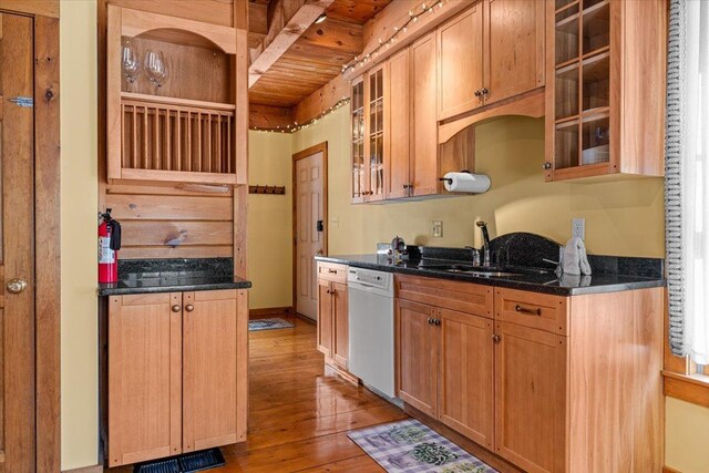 kitchen with visible vents, glass insert cabinets, light wood-type flooring, white dishwasher, and a sink
