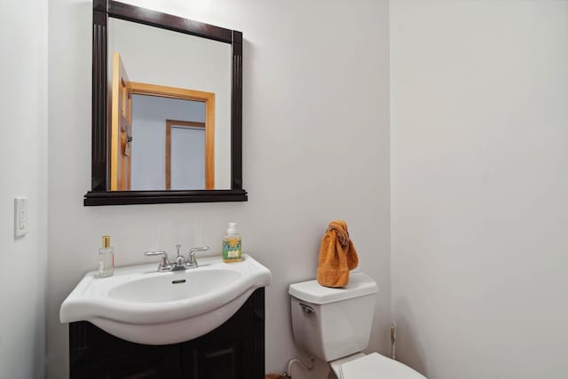 half bathroom with vanity and toilet