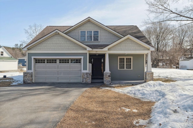 craftsman-style house with aphalt driveway, stone siding, a porch, roof with shingles, and an attached garage