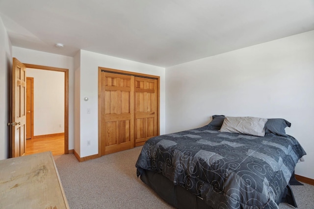 carpeted bedroom with baseboards and a closet