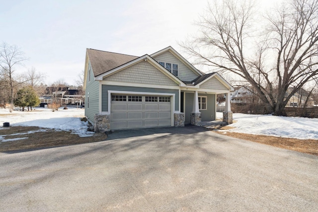 craftsman house featuring aphalt driveway, a garage, and a porch