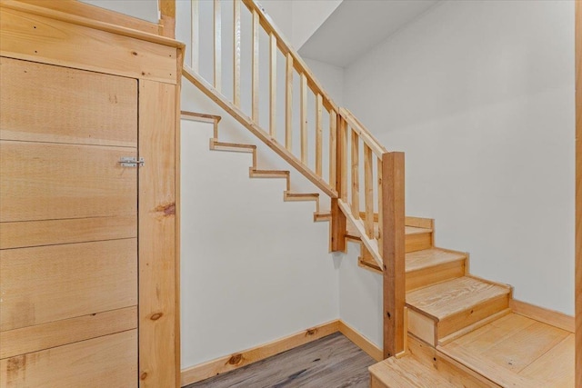 stairway featuring baseboards and wood finished floors
