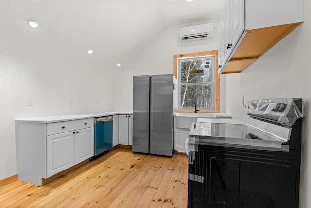 kitchen featuring light wood finished floors, dishwasher, a wall unit AC, vaulted ceiling, and freestanding refrigerator