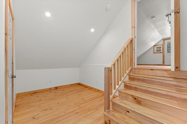bonus room featuring hardwood / wood-style floors, lofted ceiling, and baseboards